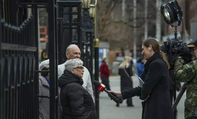 People are interviewed outside St. Michael's Cathedral Basilica in Toronto after the death of Pope Francis, on Monday, April 21, 2025. (Laura Proctor/The Canadian Press via AP)