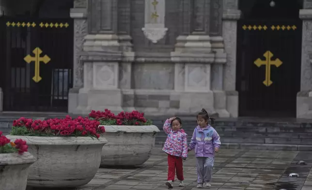 Children walks in front of the Wangfujing Catholic Church also known as East Church in Beijing, Monday, April 21, 2025. (AP Photo/Ng Han Guan)