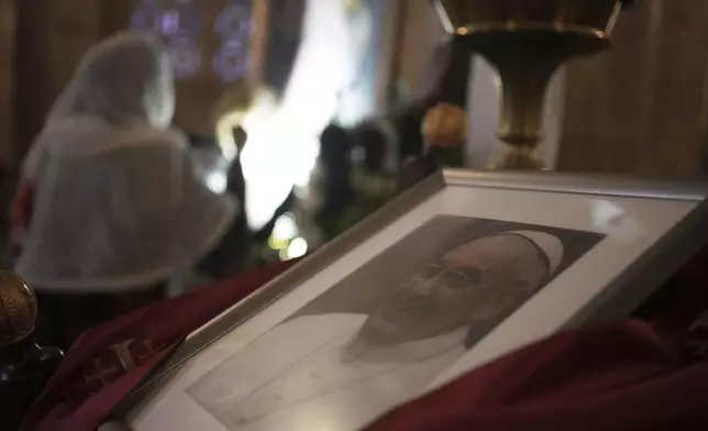 A photo of the late Pope Francis is placed at the Basilica of the Agony or Gethsemane after the news of his death at age 88, in Jerusalem, on Monday, April 21, 2025. (AP Photo/Maya Alleruzzo)