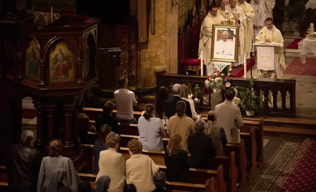 People attend a religious service for the late Pope Francis, following the announcement of his death, at the St. Joseph cathedral in Bucharest, Romania, Monday, April 21, 2025. (AP Photo/Vadim Ghirda)