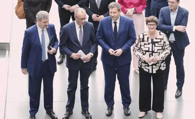 Markus Soeder, chairman of Bavarian¥s Christian Social Union party, Friedrich Merz, Christian Democratic Union party chairman and the Social Democratic Party co-leaders Lars Klingbeil and Saskia Esken, walk together after reaching an agreement between their parties on a coalition for a new German government at a news conference in Berlin, Germany, Wednesday, April 9, 2025. (AP Photo/Markus Schreiber)