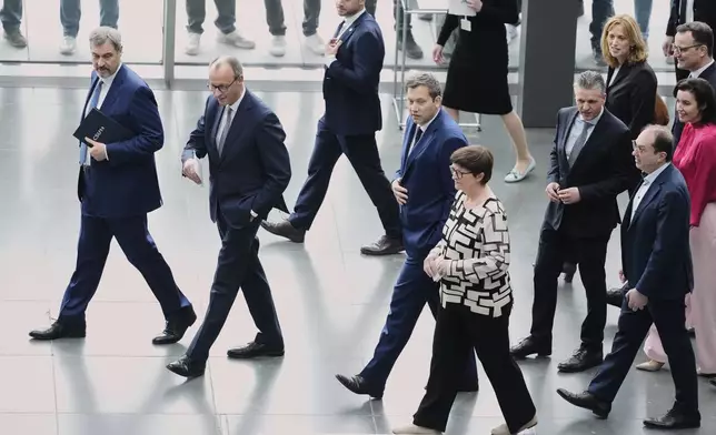 Markus Soeder, chairman of Bavarian¥s Christian Social Union party, Friedrich Merz, Christian Democratic Union party chairman and the Social Democratic Party co-leaders Lars Klingbeil and Saskia Esken, walk together after reaching an agreement between their parties on a coalition for a new German government at a news conference in Berlin, Germany, Wednesday, April 9, 2025. (AP Photo/Markus Schreiber)