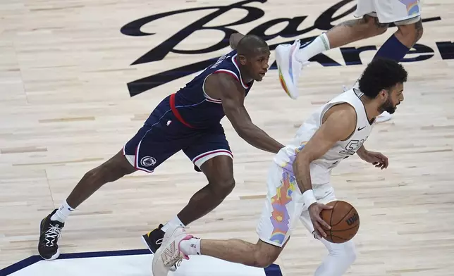 Denver Nuggets guard Jamal Murray, right, drives past Los Angeles Clippers guard Kris Dunn in the first half of Game 5 of an NBA basketball playoff series Tuesday, April 29, 2025, in Denver. (AP Photo/David Zalubowski)