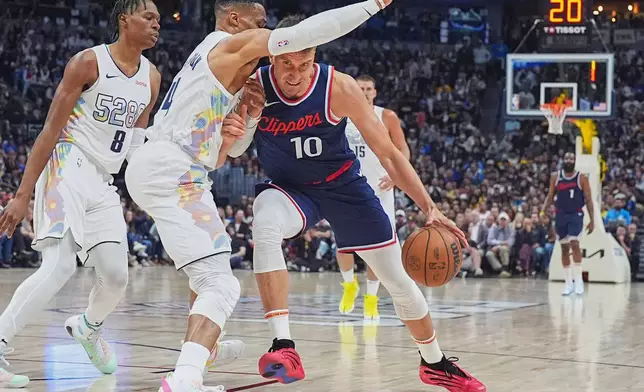 Los Angeles Clippers guard Bogdan Bogdanovic, right, struggles to drive to the basket as Denver Nuggets guard Russell Westbrook defends in the second half of Game 5 of an NBA basketball playoff series Tuesday, April 29, 2025, in Denver. (AP Photo/David Zalubowski)
