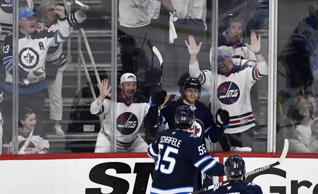 Winnipeg Jets' Kyle Connor (81) celebrates after his goal against the St. Louis Blues with Mark Scheifele (55) during the third period of Game 2 of a first-round NHL hockey playoff series in Winnipeg, Manitoba, Monday April 21, 2025. (Fred Greenslade/The Canadian Press via AP)