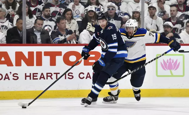 Winnipeg Jets' David Gustafsson (19) carries the puck past St. Louis Blues' Justin Faulk (72) during the second period of Game 2 of a first-round NHL hockey playoff series in Winnipeg, Manitoba, Monday April 21, 2025. (Fred Greenslade/The Canadian Press via AP)