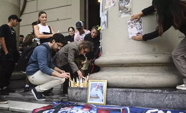 Faithful light candles for the late Pope Francis at the Cathedral in Buenos Aires, Argentina, Monday, April 21, 2025. (AP Photo/Mario De Fina)