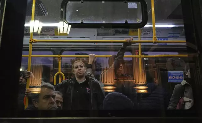 Commuters glance from a passing bus at the Basílica de San José de Flores, where the late Pope Francis worshipped as a youth, following the Vatican's announcement of his death in Buenos Aires, Argentina, Monday, April 21, 2025. (AP Photo/Rodrigo Abd)