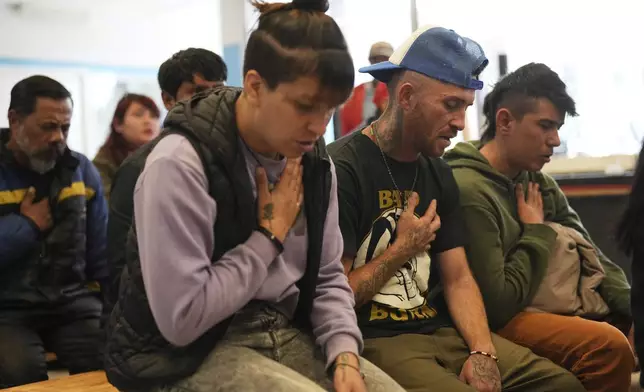 Worshippers pray during a Mass for the late Pope Francis at the Hogares de Cristo community center in the Carlos Mugica neighborhood of Buenos Aires, Argentina, part of a network for drug addicts originally supported by then-Archbishop Jorge Bergoglio, Monday, April 21, 2025. (AP Photo/Rodrigo Abd)