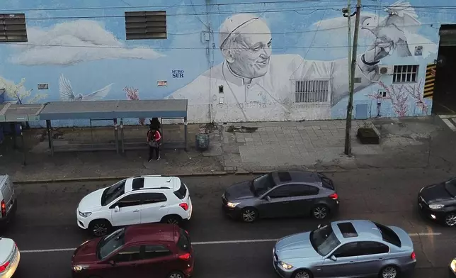 Vehicles drive past a mural of the late Pope Francis' in Buenos Aires, in Buenos Aires, Argentina Monday, April 21, 2025. (AP Photo/Mario De Fina)