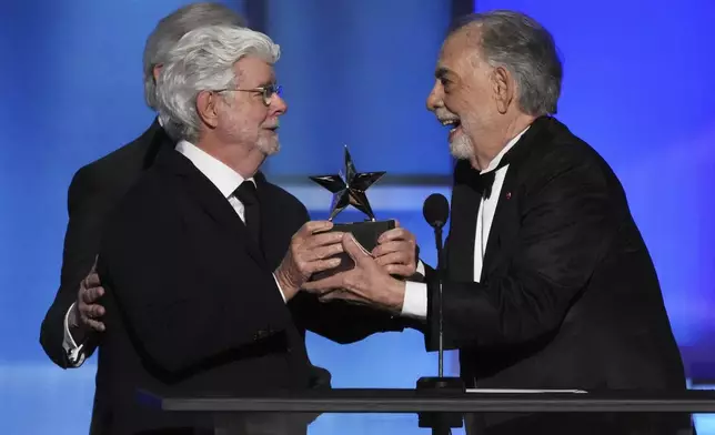 Filmmaker Francis Ford Coppola, right, accepts the 50th AFI Life Achievement Award from presenter George Lucas during a gala tribute to Coppola on Saturday, April 26, 2025, at the Dolby Theatre in Los Angeles. (AP Photo/Chris Pizzello)