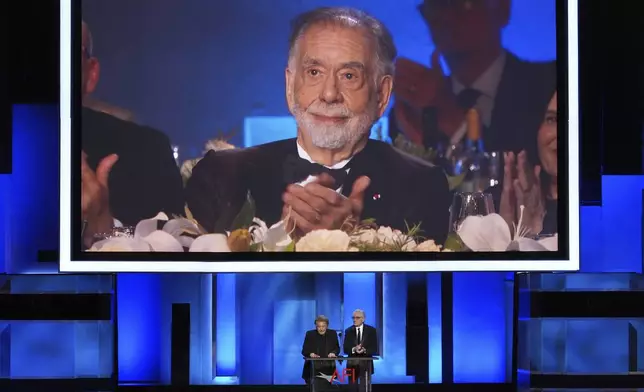 Filmmaker Francis Ford Coppola is seen on a video monitor as actors Al Pacino, left, and Robert De Niro talk about his career during the 50th AFI Life Achievement Award tribute to Coppola on Saturday, April 26, 2025, at the Dolby Theatre in Los Angeles. (AP Photo/Chris Pizzello)