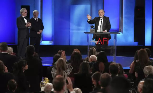 Filmmaker Francis Ford Coppola, right, gets a standing ovation as presenters Steven Spielberg, far left, and George Lucas look on during the 50th AFI Life Achievement Award tribute to Coppola on Saturday, April 26, 2025, at the Dolby Theatre in Los Angeles. (AP Photo/Chris Pizzello)
