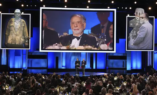 Filmmaker Francis Ford Coppola is displayed on a screen as actors Al Pacino, left, and Robert De Niro talk about his career during the 50th AFI Life Achievement Award tribute to Coppola on Saturday, April 26, 2025, at the Dolby Theatre in Los Angeles. (AP Photo/Chris Pizzello)