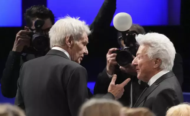 Actors Harrison Ford, left, and Dustin Hoffman mingle in the audience during the 50th AFI Life Achievement Award tribute to Francis Ford Coppola on Saturday, April 26, 2025, at the Dolby Theatre in Los Angeles. (AP Photo/Chris Pizzello)