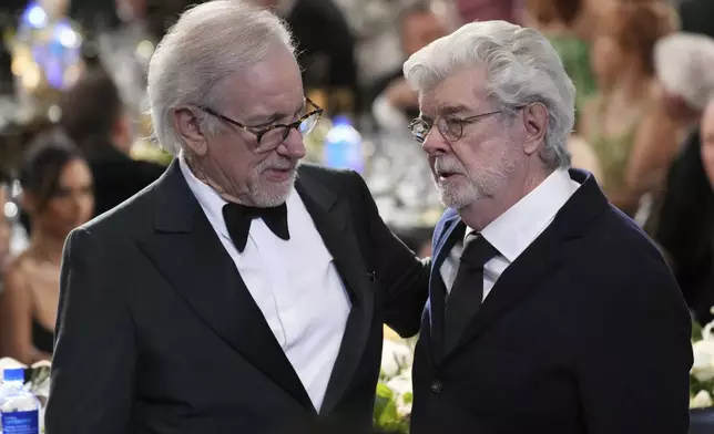 Filmmakers Steven Spielberg, left, and George Lucas mingle during the 50th AFI Life Achievement Award tribute to Francis Ford Coppola on Saturday, April 26, 2025, at the Dolby Theatre in Los Angeles. (AP Photo/Chris Pizzello)