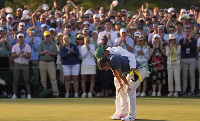 Rory McIlroy, of Northern Ireland, is hugged by caddie Harry Diamond after winning in a playoff against Justin Rose, of England, after the final round the Masters golf tournament, Sunday, April 13, 2025, in Augusta, Ga.(AP Photo/Ashley Landis)