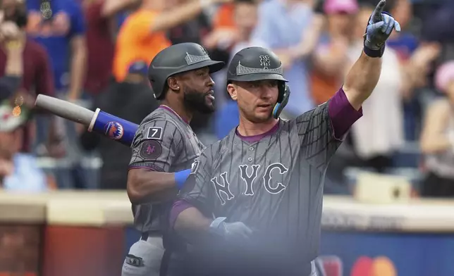 New York Mets' Starling Marte, left, watches as Pete Alonso gestures to fans after hitting a home run during the eighth inning of a baseball game against the St. Louis Cardinals Saturday, April 19, 2025, in New York. (AP Photo/Frank Franklin II)