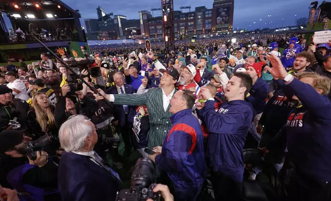 LSU offensive tackle Will Campbell, center, celebrates with fans after being chosen by the New England Patriots with the fourth overall pick during the first round of the NFL football draft, Thursday, April 24, 2025, in Green Bay, Wis. (AP Photo/Matt Ludtke)
