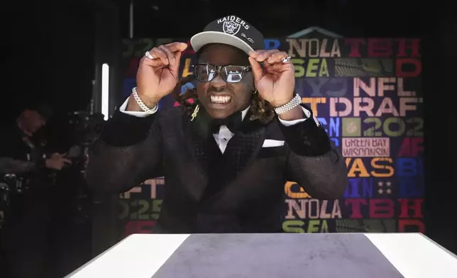 Boise State running back Ashton Jeanty puts on a hat after being chosen by the Las Vegas Raiders with the sixth overall pick during the first round of the NFL football draft, Thursday, April 24, 2025, in Green Bay, Wis. (AP Photo/Jeff Roberson)