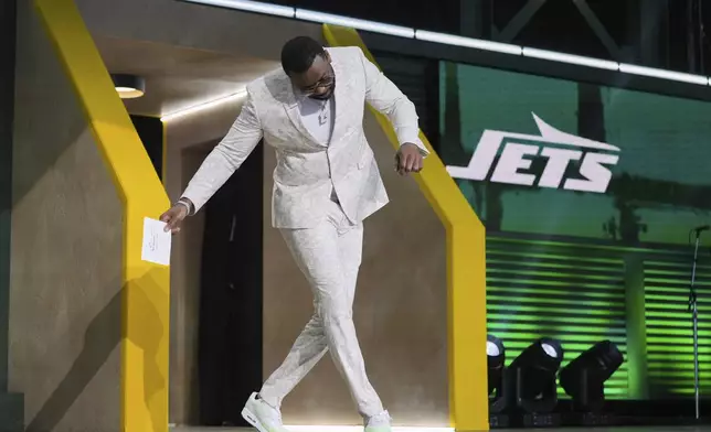 Former NFL player John Abraham dances as he arrives on stage to announce a pick by the New York Jets during the second round of the NFL football draft, Friday, April 25, 2025, in Green Bay, Wis. (AP Photo/Jeff Roberson)