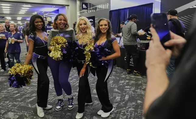 Baltimore Ravens cheerleaders pose with a fan for photos during the team's NFL football draft party at M&amp;T Bank Stadium in Baltimore, Thursday, April 24, 2025. (AP Photo/Stephanie Scarbrough)