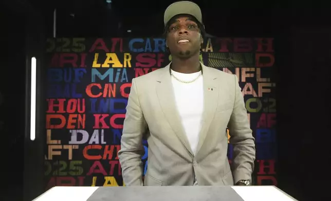 Miami quarterback Cam Ward puts on a hat after being chosen by the Tennessee Titans with the first overall pick during the first round of the NFL football draft, Thursday, April 24, 2025, in Green Bay, Wis. (AP Photo/Jeff Roberson)