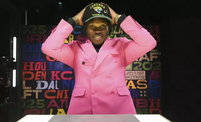Colorado wide receiver Travis Hunter puts on a hat after being chosen by the Jacksonville Jaguars with the second overall pick during the first round of the NFL football draft, Thursday, April 24, 2025, in Green Bay, Wis. (AP Photo/Jeff Roberson)