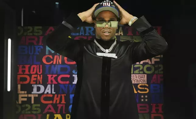 Penn State defensive end Abdul Carter puts on a hat after being chosen by the New York Giants with the third overall pick during the first round of the NFL football draft, Thursday, April 24, 2025, in Green Bay, Wis. (AP Photo/Jeff Roberson)