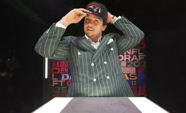 LSU offensive tackle Will Campbell puts on a hat after being chosen by the New England Patriots with the fourth overall pick during the first round of the NFL football draft, Thursday, April 24, 2025, in Green Bay, Wis. (AP Photo/Jeff Roberson)