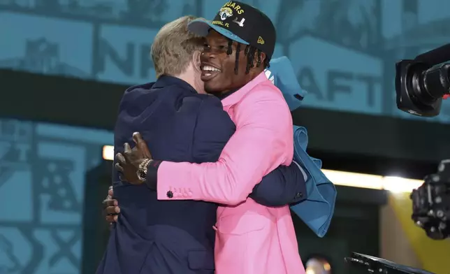 Colorado wide receiver Travis Hunter, right, embraces NFL Commissioner Roger Goodell after being chosen by the Jacksonville Jaguars with the second overall pick during the first round of the NFL football draft, Thursday, April 24, 2025, in Green Bay, Wis. (AP Photo/Jeff Roberson)
