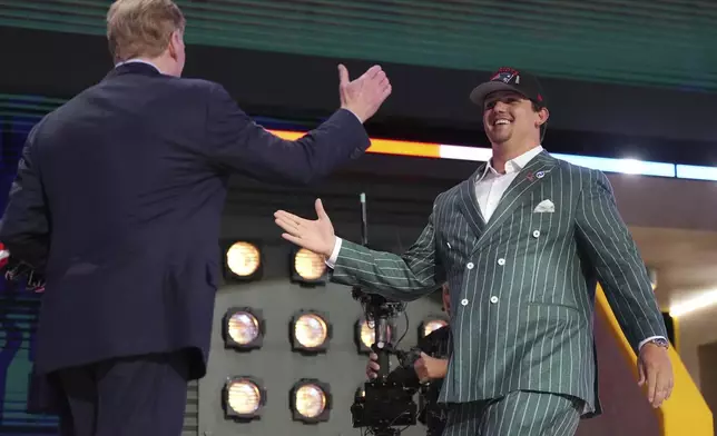 LSU offensive tackle Will Campbell, right, celebrates with NFL Commissioner Roger Goodell after being chosen by the New England Patriots with the fourth overall pick during the first round of the NFL football draft, Thursday, April 24, 2025, in Green Bay, Wis. (AP Photo/Jeff Roberson)