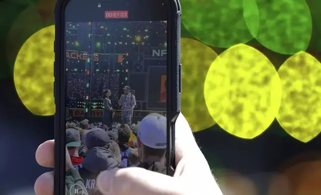A person takes a video of Texas defensive lineman Barryn Sorrell, right, after he was chose chosen by the Green Bay Packers with the 124th overall pick during the third day of the NFL football draft, Saturday, April 26, 2025, in Green Bay, Wis. (AP Photo/Matt Ludtke)