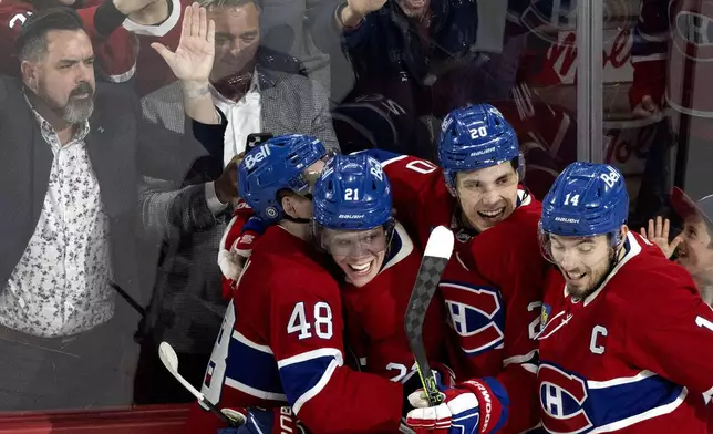 Montreal Canadiens' Kaiden Guhle (21) celebrates his goal against the Carolina Hurricanes with Lane Hutson (48), Juraj Slafkovsky (20) and Nick Suzuki (14) during second period NHL hockey action in Montreal on Wednesday, April 16, 2025. (Allen McInnis/The Canadian Press via AP)