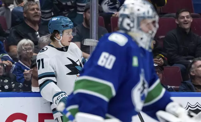 San Jose Sharks' Macklin Celebrini (71) celebrates after his goal as Vancouver Canucks goaltender Nikita Tolopilo (60) skates to the bench during the second period of an NHL hockey game in Vancouver, British Columbia, Monday, April 14, 2025. (Ethan Cairns/The Canadian Press via AP)