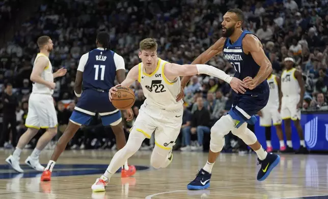 Utah Jazz forward Kyle Filipowski (22) works toward the basket as Minnesota Timberwolves center Rudy Gobert (27) defends during the first half of an NBA basketball game, Sunday, April 13, 2025, in Minneapolis. (AP Photo/Abbie Parr)