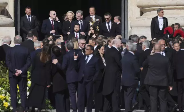 European Commission President Ursula von der Leyen, background center, and other guests arrive for the funeral of Pope Francis in St. Peter's Square at the Vatican, Saturday, April 26, 2025. (AP Photo/Andrew Medichini)