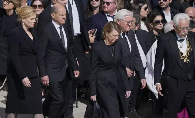 German Chancellor Olaf Scholz, second from left, and wife Britta Ernst follow Germany's President Frank Walter Steinmeier and wife Elke Büdenbender as they arrive for the funeral of Pope Francis in St. Peter's Square at the Vatican, Saturday, April 26, 2025. (AP Photo/Gregorio Borgia)
