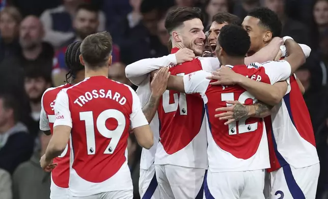 Arsenal's Jakub Kiwior celebrates with teammates after scoring his sides first goal during the English Premier League soccer match between Arsenal and Crystal Palace at Emirates stadium in London, Wednesday, April 23, 2025. (AP Photo/Ian Walton)