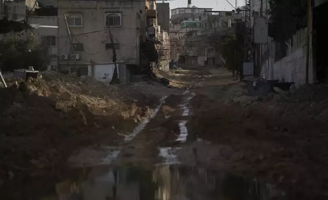 A damaged street winds toward the Tulkarem refugee camp in the West Bank city of Tulkarem, Thursday, April 3, 2025. (AP Photo/Leo Correa)