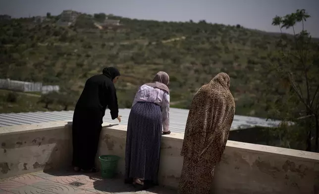 Palestinian women stand at a local multipurpose hall that has been used as a temporary shelter for displaced people in the village of Kafr al-Labad, near the West Bank city of Tulkarem, Thursday, April 3, 2025. (AP Photo/Leo Correa)