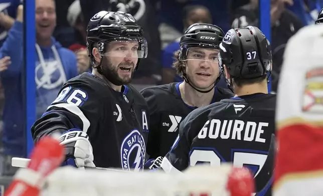 Tampa Bay Lightning right wing Nikita Kucherov (86) celebrates his goal against the Florida Panthers with center Brayden Point (21) and center Yanni Gourde (37) during the second period of an NHL hockey game Tuesday, April 15, 2025, in Tampa, Fla. (AP Photo/Chris O'Meara)