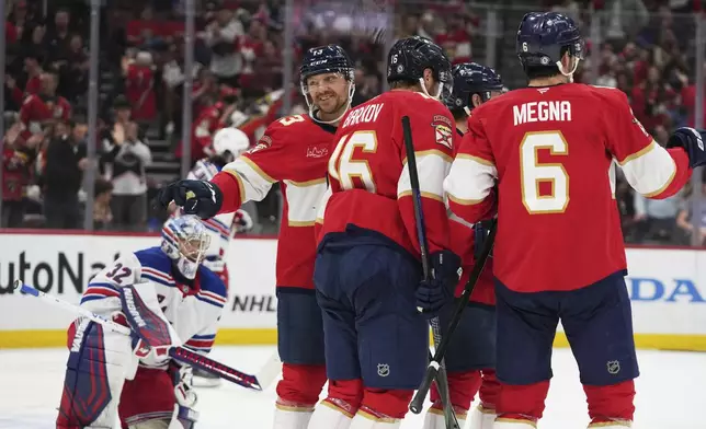 Florida Panthers center Sam Reinhart, second from left, reacts after scoring a goal against New York Rangers goaltender Jonathan Quick (32) during the second period of an NHL hockey game, Monday, April 14, 2025, in Sunrise, Fla. (AP Photo/Lynne Sladky)
