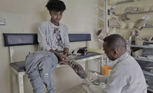 Hiluf Haile, 24-year-old, Tigrayan former combatant of the recent war being examined by a doctor at Ortho-Physiotherapy Centre in Mekele, Tigray region of northern Ethiopia Friday, Feb. 14, 2025. (AP Photo/Amanuel Birhane)