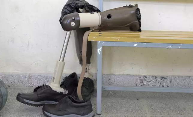 A prosthetic leg backdropped by wounded Tigrayan former combatant is seen at Ortho-Physiotherapy Centre at Mekele in Tigray region of northern Ethiopia Friday, Feb. 14, 2025. (AP Photo/Amanuel Birhane)