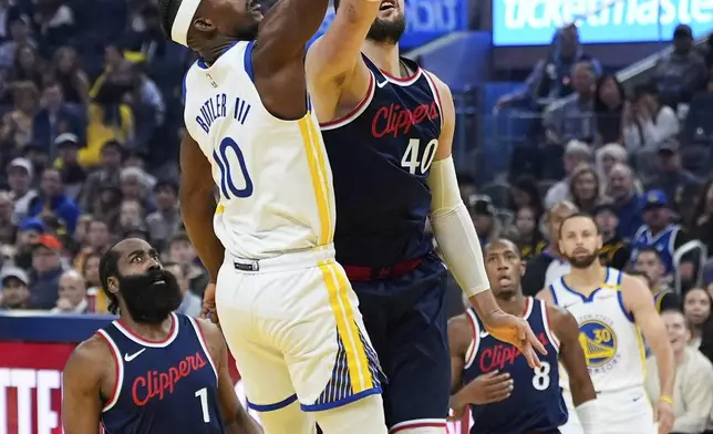 Golden State Warriors forward Jimmy Butler III (10) shoots while defended by Los Angeles Clippers center Ivica Zubac (40) during the first half of an NBA basketball game Sunday, April 13, 2025, in San Francisco. (AP Photo/Godofredo A. Vásquez)