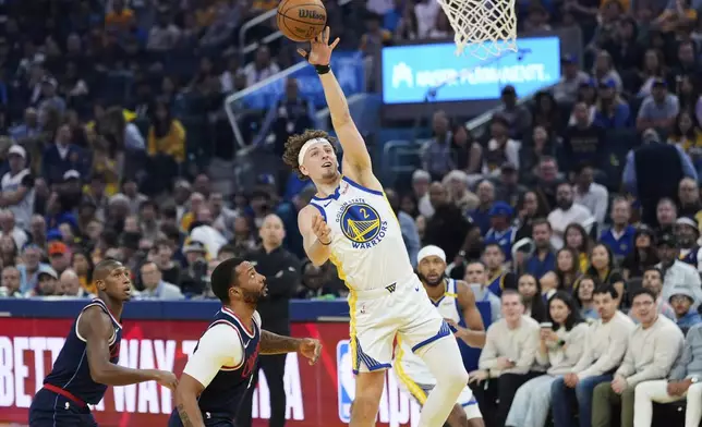 Golden State Warriors guard Brandin Podziemski (2) shoots next to Los Angeles Clippers guard Norman Powell, second from left, during the first half of an NBA basketball game Sunday, April 13, 2025, in San Francisco. (AP Photo/Godofredo A. Vásquez)