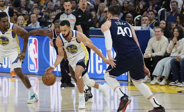 Golden State Warriors guard Stephen Curry (30) moves the ball while defended by Los Angeles Clippers guard Kris Dunn, second from left, during the first half of an NBA basketball game Sunday, April 13, 2025, in San Francisco. (AP Photo/Godofredo A. Vásquez)