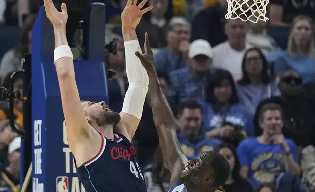 Los Angeles Clippers center Ivica Zubac, left, shoots while defended by Golden State Warriors forward Draymond Green during the first half of an NBA basketball game Sunday, April 13, 2025, in San Francisco. (AP Photo/Godofredo A. Vásquez)