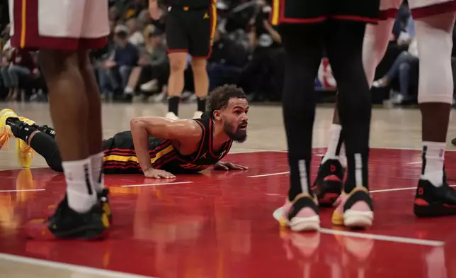 Atlanta Hawks guard Trae Young (11) falls and gets a foul in the first half of an NBA play-in tournament basketball game against the Miami Heat, Friday, April 18, 2025, in Atlanta. (AP Photo/Brynn Anderson)